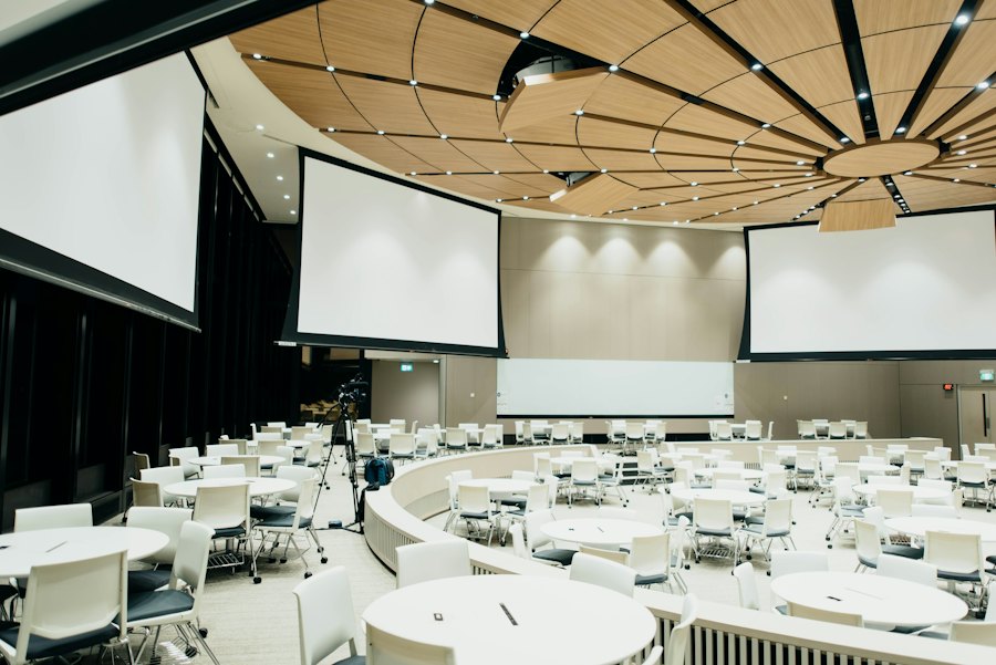 Congreszaal met ronde tafels en schermen